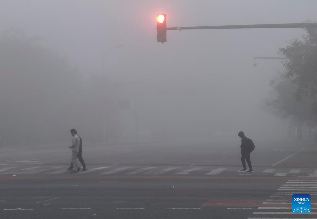 Người dân đi bộ trên phố giữa sương mù ở Bắc Kinh, thủ đô Trung Quốc. Ảnh: Tân Hoa xã
