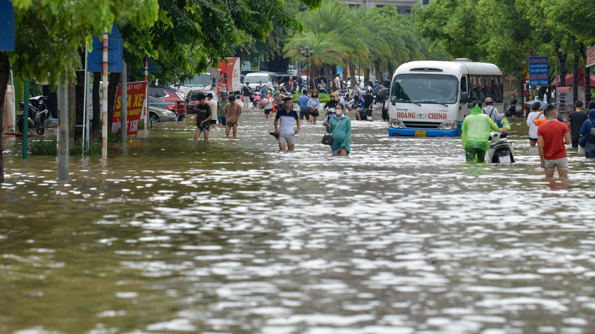 Sáng 24/7, nước ngập sâu khiến các phương tiện không thể đi qua, người dân buộc phải lội nước di chuyển ra ngoài.